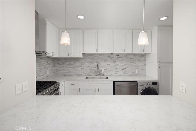 kitchen featuring washer / dryer, white cabinetry, appliances with stainless steel finishes, and sink