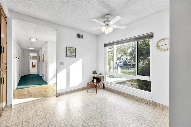 interior space featuring ceiling fan and a textured ceiling