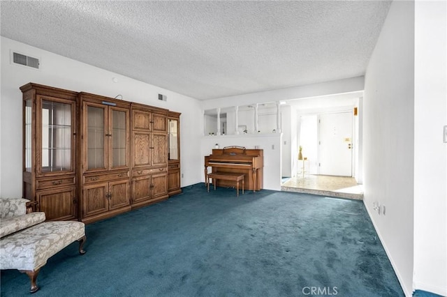 interior space featuring dark carpet and a textured ceiling