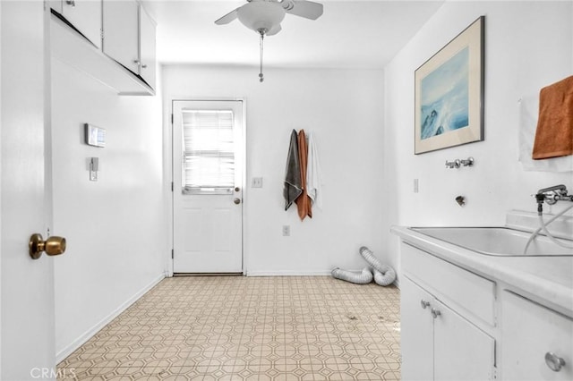 interior space with ceiling fan, cabinets, and sink