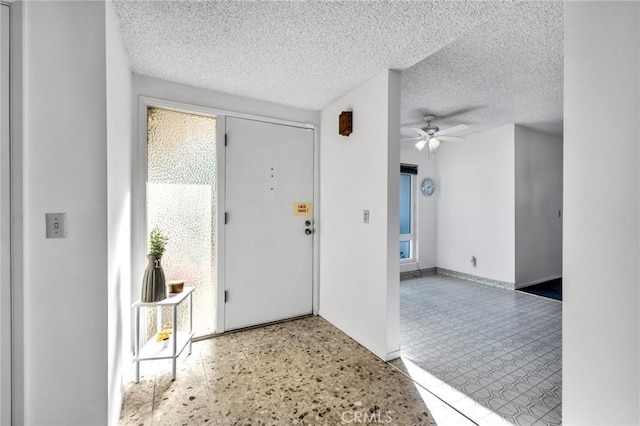 entrance foyer featuring a textured ceiling and ceiling fan