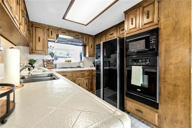 kitchen featuring decorative backsplash, extractor fan, sink, black appliances, and tile countertops