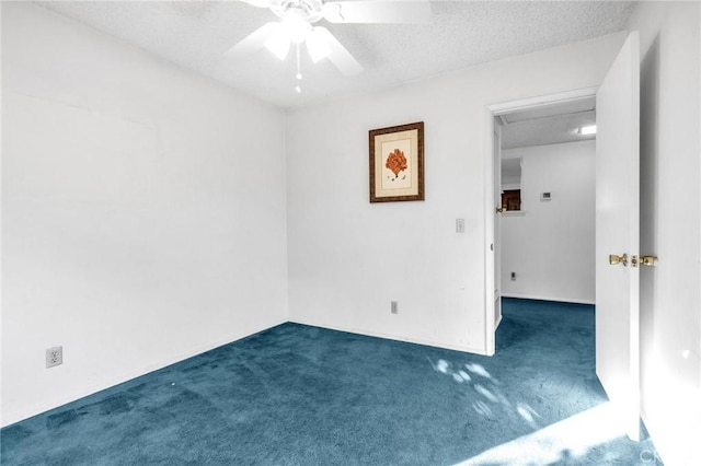 empty room featuring ceiling fan, dark carpet, and a textured ceiling