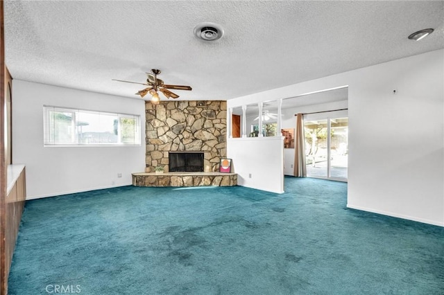 unfurnished living room featuring carpet, a healthy amount of sunlight, a fireplace, and a textured ceiling