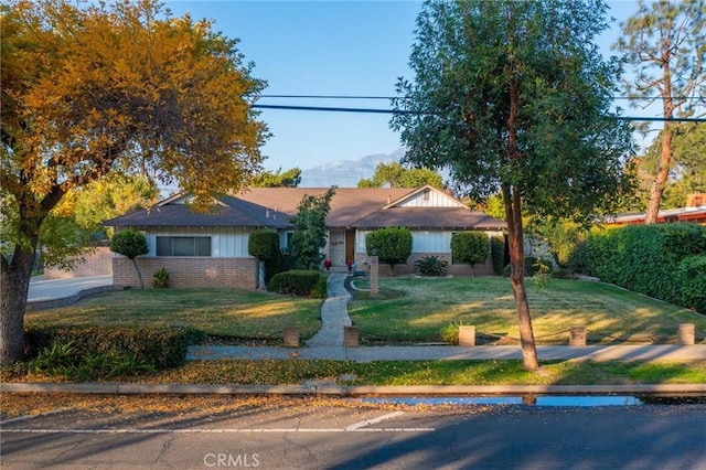 ranch-style home with a mountain view and a front lawn