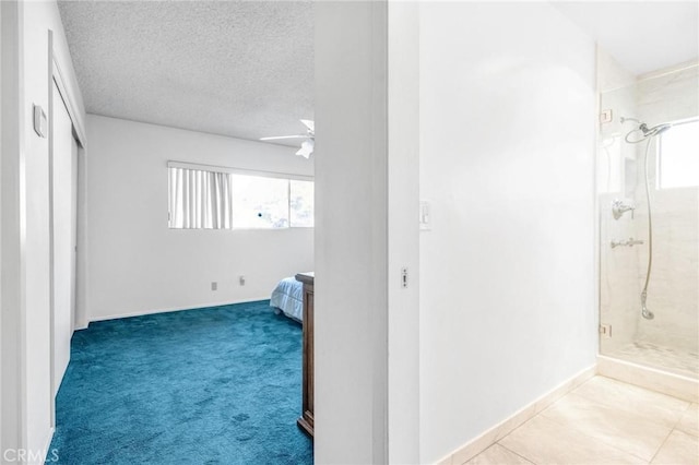 bedroom with a textured ceiling, ceiling fan, light carpet, and multiple windows