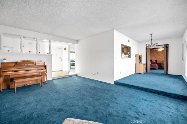 interior space featuring carpet, a chandelier, and a textured ceiling