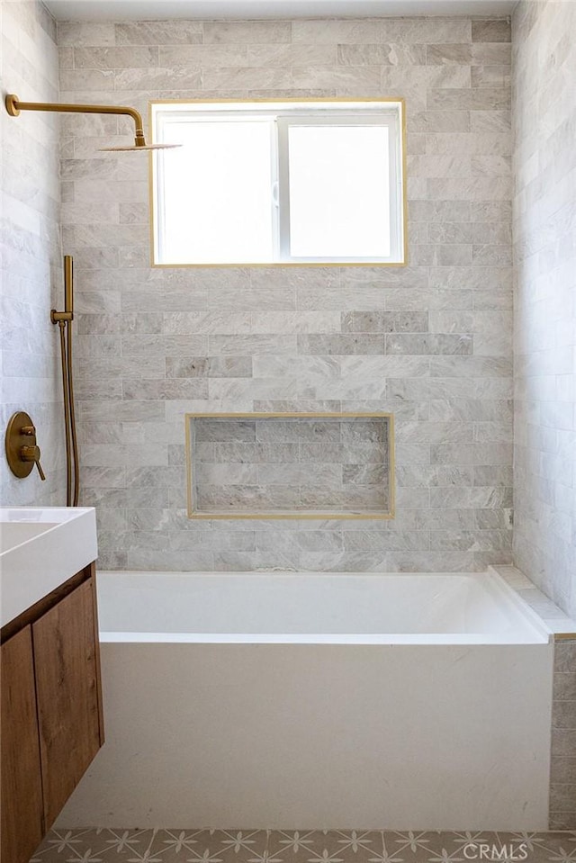 bathroom featuring vanity and tiled shower / bath