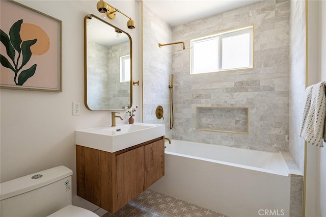 full bathroom featuring tile patterned floors, vanity, tiled shower / bath combo, and toilet