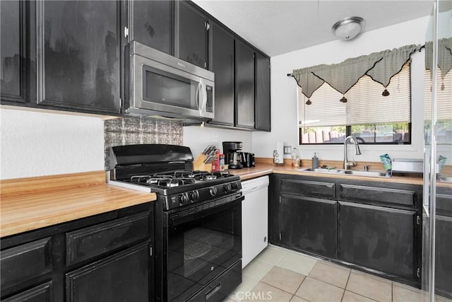 kitchen featuring black gas range, sink, white dishwasher, and light tile patterned flooring