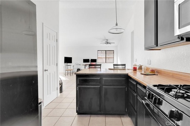 kitchen featuring kitchen peninsula, ceiling fan, light tile patterned floors, decorative light fixtures, and black range