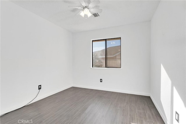 empty room with ceiling fan and dark hardwood / wood-style flooring