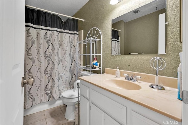 bathroom featuring tile patterned floors, walk in shower, vanity, and toilet