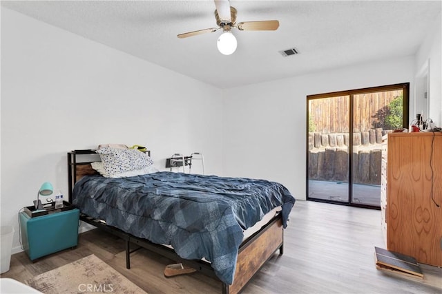 bedroom with access to outside, ceiling fan, and wood-type flooring