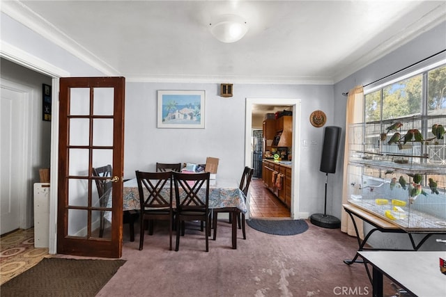 carpeted dining space featuring ornamental molding