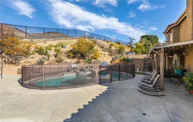 view of swimming pool with a mountain view and a patio area