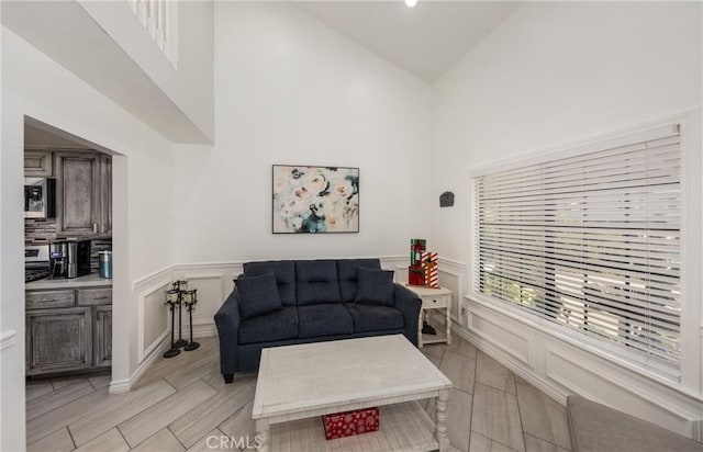 living room with light hardwood / wood-style flooring and high vaulted ceiling