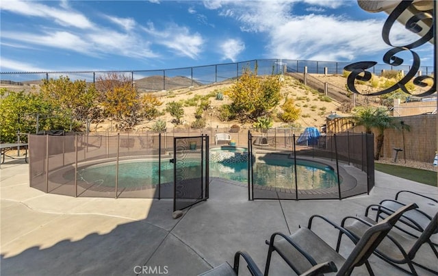 view of pool with a mountain view, an in ground hot tub, and a patio