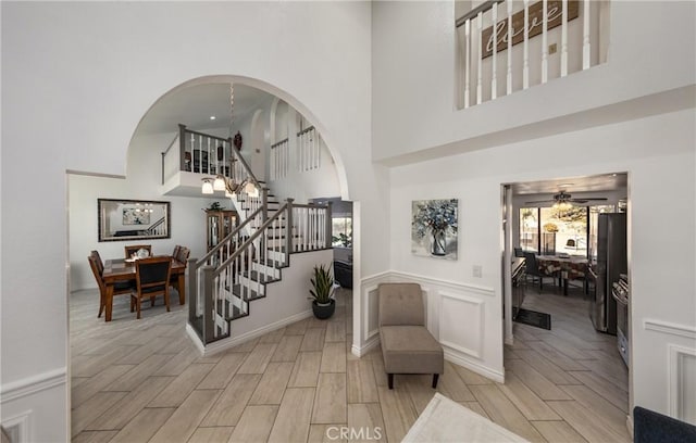 entryway with a high ceiling, light wood-type flooring, and ceiling fan