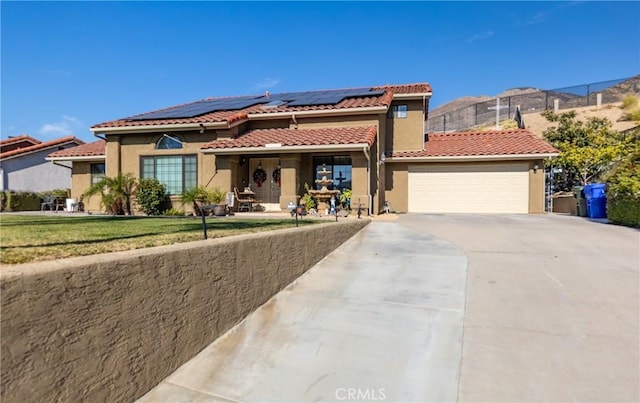 mediterranean / spanish-style home with a mountain view, a front lawn, and a garage