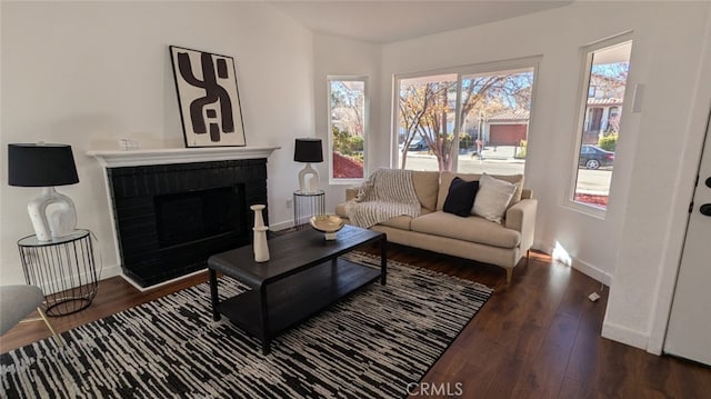 living room featuring a fireplace and dark wood-type flooring