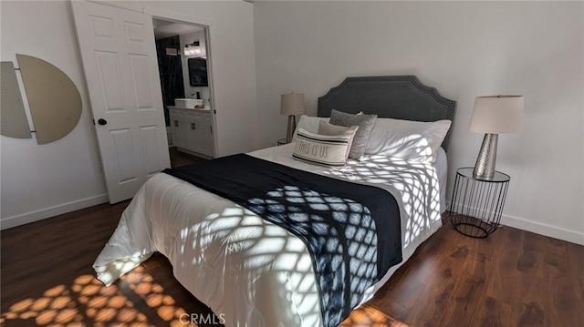 bedroom with dark hardwood / wood-style flooring and ensuite bathroom