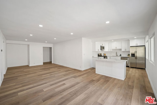 kitchen with sink, stainless steel appliances, white cabinets, light hardwood / wood-style floors, and a kitchen island