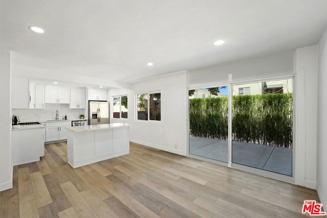 kitchen featuring white cabinets, stainless steel appliances, light hardwood / wood-style flooring, and a wealth of natural light