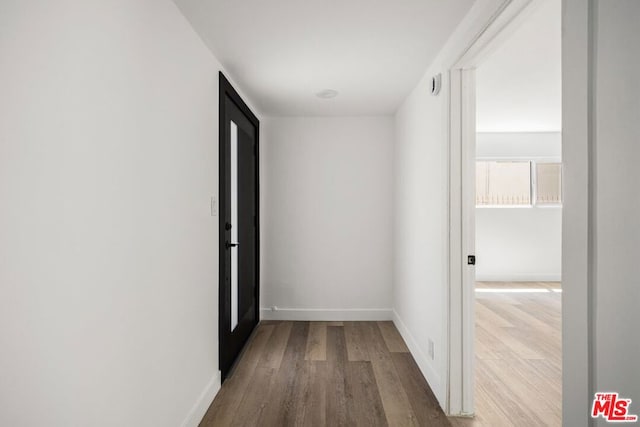 corridor with hardwood / wood-style floors