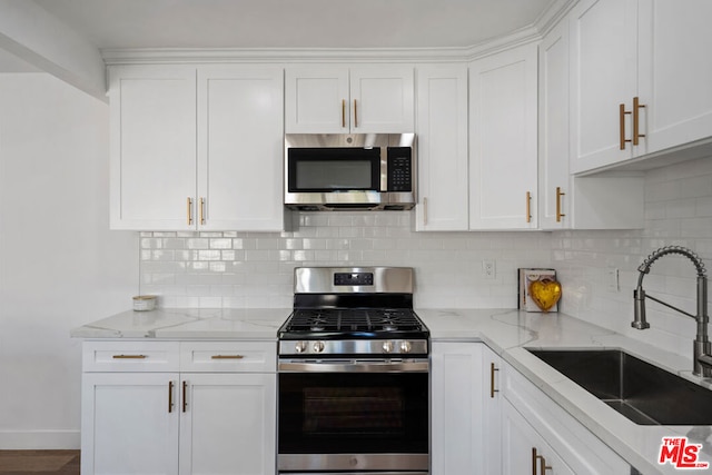 kitchen featuring white cabinets, light stone countertops, sink, and appliances with stainless steel finishes