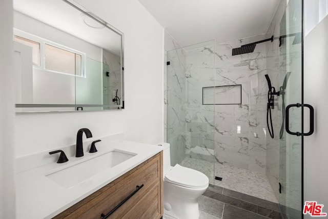 bathroom featuring tile patterned floors, vanity, toilet, and a shower with shower door