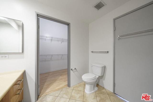 bathroom featuring toilet, vanity, and tile patterned flooring