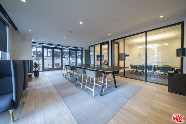 dining room featuring light wood-type flooring, french doors, and floor to ceiling windows