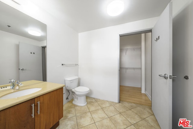 bathroom with toilet, tile patterned floors, and vanity