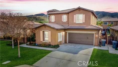 front of property featuring a lawn and a garage