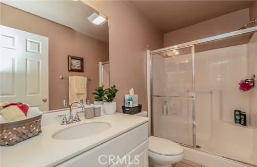 bathroom featuring vanity, toilet, and an enclosed shower