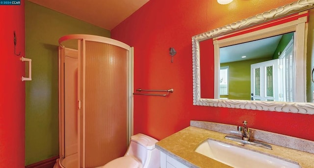 bathroom with vanity, a shower with shower door, and lofted ceiling