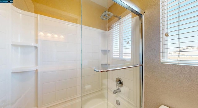 bathroom with a wealth of natural light and enclosed tub / shower combo