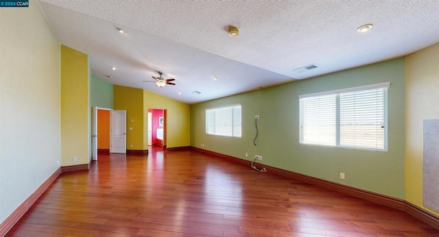 empty room with a textured ceiling, ceiling fan, dark hardwood / wood-style flooring, and lofted ceiling