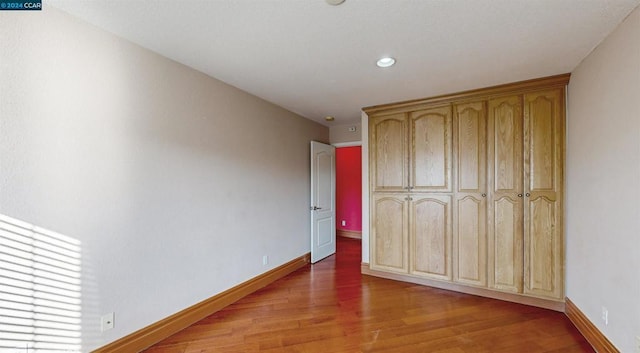 unfurnished bedroom with wood-type flooring and a closet