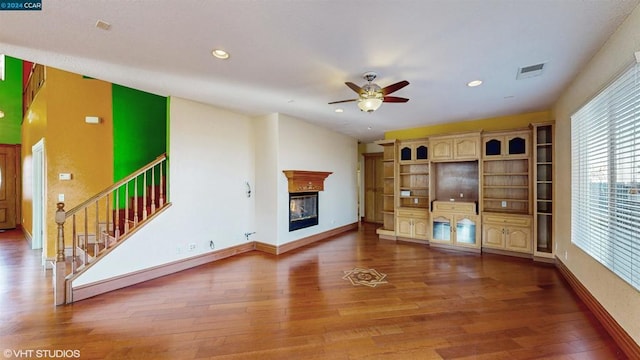 unfurnished living room featuring ceiling fan and hardwood / wood-style floors