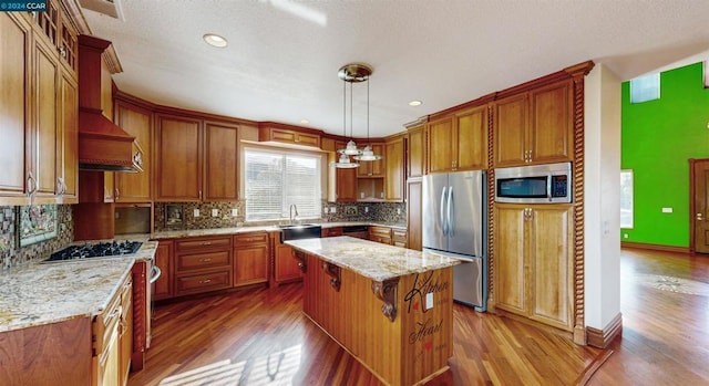 kitchen with decorative backsplash, appliances with stainless steel finishes, dark hardwood / wood-style flooring, a center island, and hanging light fixtures