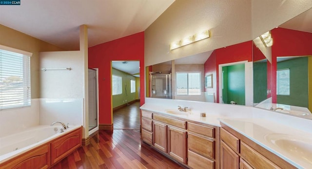 bathroom with hardwood / wood-style flooring, vanity, shower with separate bathtub, and vaulted ceiling