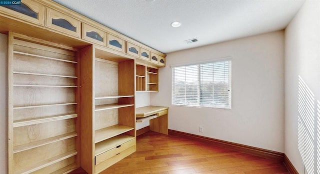 interior space featuring a textured ceiling and hardwood / wood-style flooring