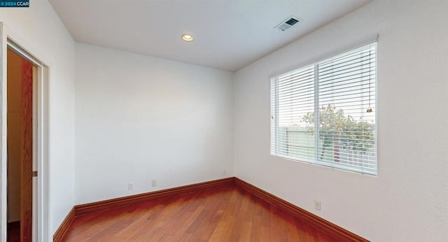 spare room with wood-type flooring and a wealth of natural light