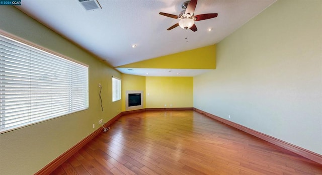 spare room with light hardwood / wood-style floors, vaulted ceiling, and ceiling fan