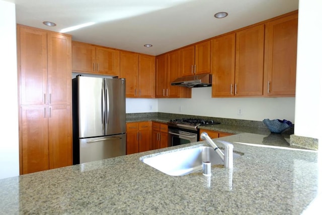 kitchen featuring light stone counters, sink, and appliances with stainless steel finishes