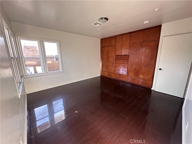 unfurnished room with dark hardwood / wood-style flooring