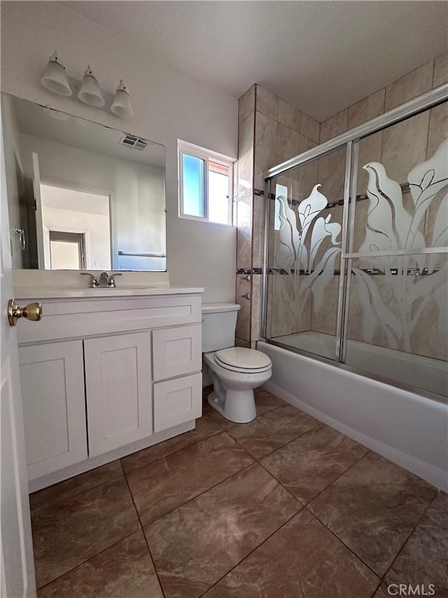 full bathroom with shower / bath combination with glass door, tile patterned floors, vanity, and toilet