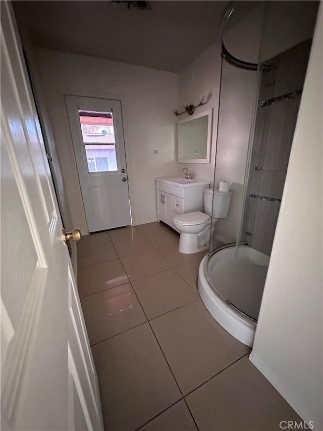 bathroom featuring tile patterned floors, vanity, toilet, and an enclosed shower